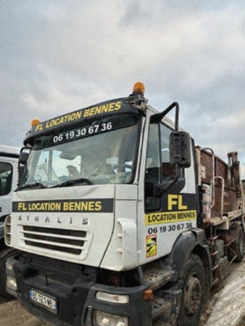 Le camion porte-benne FL Location Bennes, avec le numéro de l'entreprise
