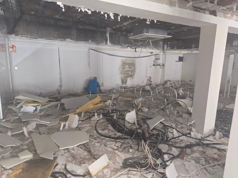 Intérieur d'un local commercial en cours de curage, cloisons déposées et réseaux dégagés