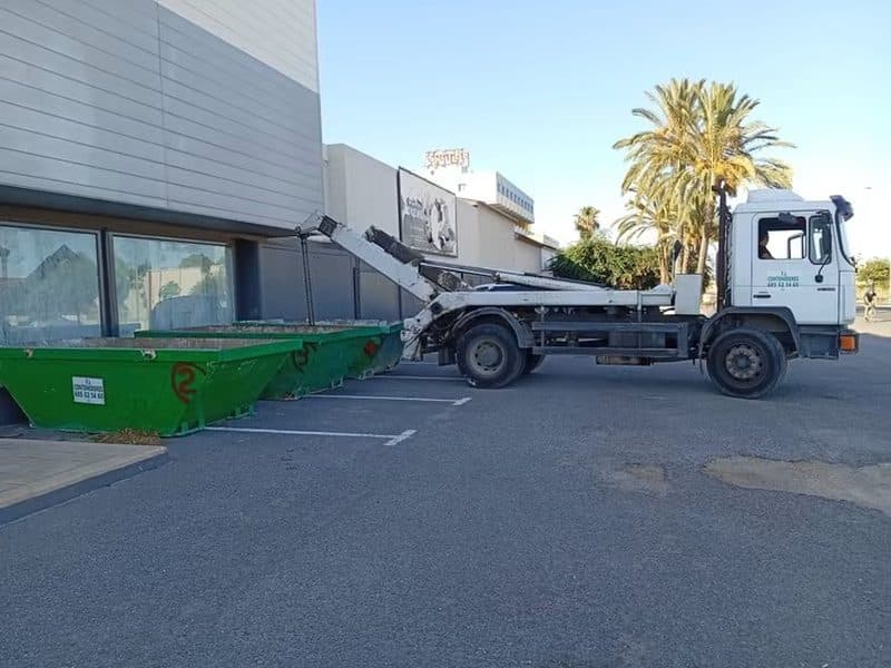 Camion procédant au remplacement d'une benne pleine sur un chantier